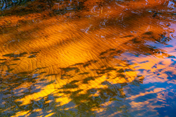 the water surface of a river or lake with sun glare at sunset