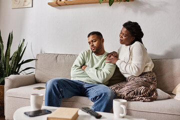 African American couple wearing cozy sweaters during winter, woman calming her man