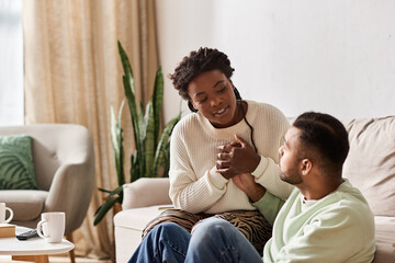 Fototapeta premium A happy couple shares warmth and joy in their cozy living room, embracing winter love together.