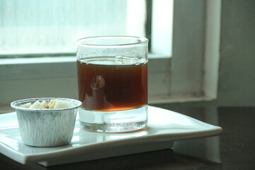 Transparent double wall glass, with black coffee, on white background. Cup with black liquid on white rotating table.