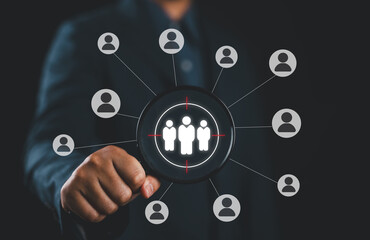 Target audience and customer focus concept. Man hold magnifying glass highlighting a group of...