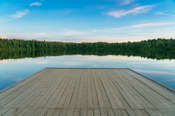 wooden platform, swimming pool on the shore of a forest lake, summer evening