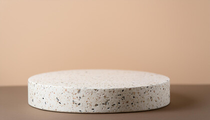 White round terrazzo podium for product presentation. Empty pedestal. Beige wall. Mock-up.
