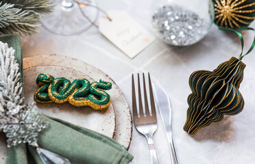 Stylish plates, napkin, glass, champagne, Christmas tree branches and Christmas decorations on a...