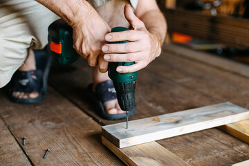 work with a screwdriver. sewing together wooden block with a screw