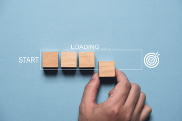 Hand assembly wooden block cube to loading icon bar from start to achieve target on blue background...