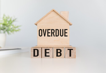 Overdue Debt text on small wooden house with wooden cubes on white background.