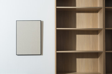 Empty bookcase and blank picture hanging on the wall