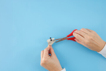 hand is holding the cardboard egg box cone element in one hand and the scissors in the other. step...
