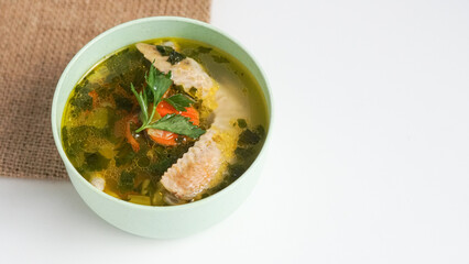 Homemade chicken soup in a bowl on a white background