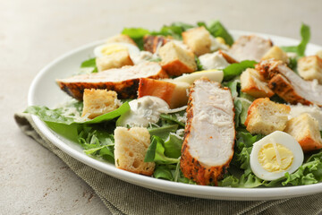 Tasty Caesar salad with chicken on light grey table, closeup