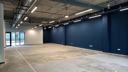 A dark blue wall sets the tone for a modern interior with an exposed concrete floor and industrial-style lighting, dark blue wall, industrial style