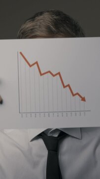Businessman holding a negative financial chart, bankruptcy and financial crisis concept