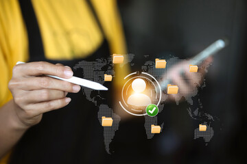 A person interacting with a holographic digital network, displaying folders, a world map, and a user profile.