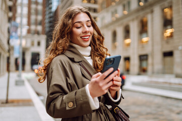 Beautiful woman using phone outdoor in the street.  Concept of vacation, blogging, technology, weekend.