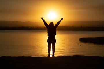 silhouette of a girl raising her arms