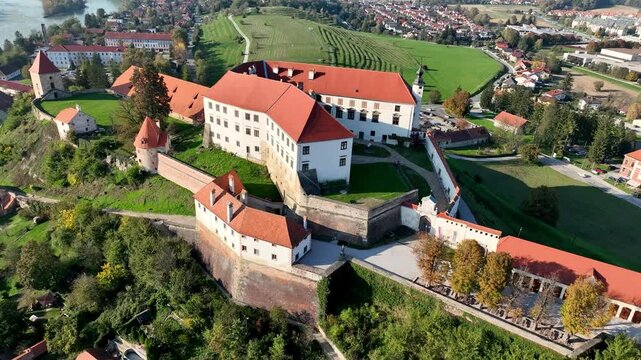 Aerial video with beautiful Ptuj castle on a hilltop above houses of Ptuj old town along Drava river in Slovenia