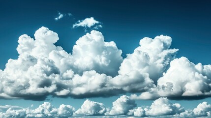 Dramatic cumulus clouds against a clear blue sky, showcasing the dynamic and fluffy textures of the cloud formations.