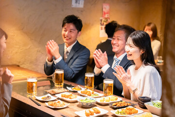 居酒屋でお祝いをするビジネスパーソン