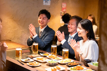 居酒屋でお祝いをするビジネスパーソン