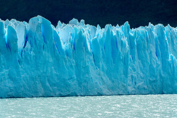 Perito Moreno glacier front in Patagonia with crystalline blue ice formations contrasting with the...