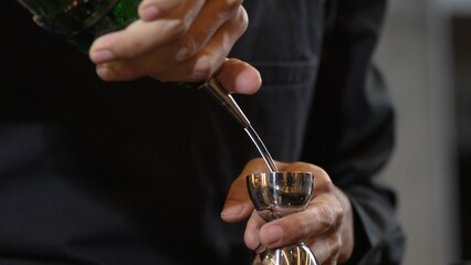 Closeup mixing hand bartender holding jigger to measure juice into shaker design preparation for...