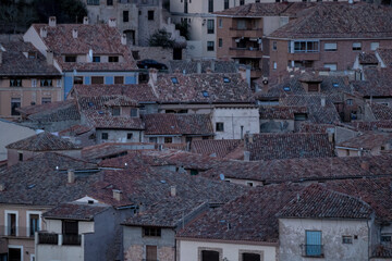 Cluster of traditional tiled rooftops in a quiet medieval village at dusk © larrui