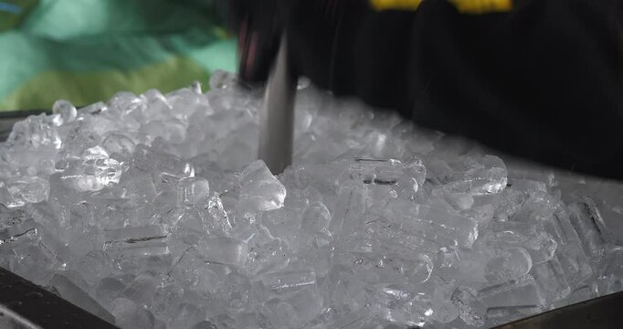 Close up of ice cubes being poured into the crushing machine.