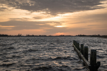 Sunset at Langweerder Wielen (Frisian: Langwarder Wielen), Frisian Lake in the Netherlands. View of the church tower of Langweer. 