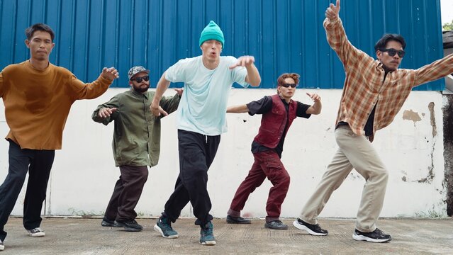 Group of hip hop choreographer dancing street dance together at wall. Young break dancer practicing break dance, moving to modern rhythm, express feeling of lively. Outdoor 2024. Hiphop.