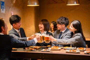 居酒屋で盛大に乾杯をするビジネスパーソン