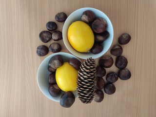 Yellow lemons and shiny brown chestnuts on the table