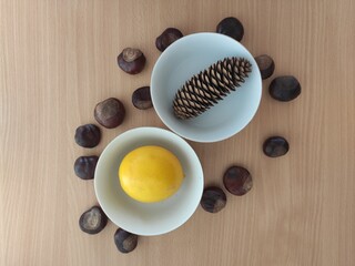 Yellow lemons and shiny brown chestnuts on the table