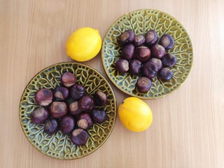 Yellow lemons and shiny brown chestnuts on the table