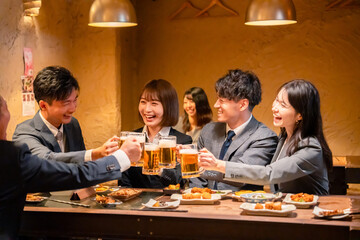 居酒屋で盛大に乾杯をするビジネスパーソン