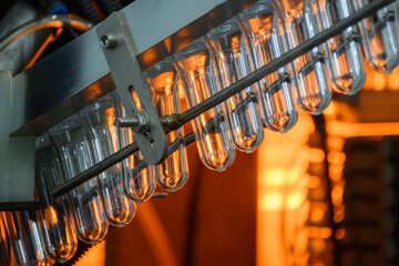 Conveyor belt deliver the preform shape to the  blow mold machine.