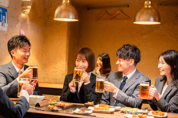 居酒屋で盛大に乾杯をするビジネスパーソン