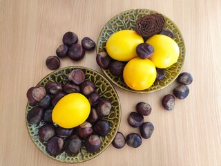 Yellow lemons and shiny brown chestnuts on the table