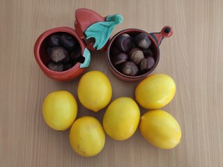 Yellow lemons and shiny brown chestnuts on the table