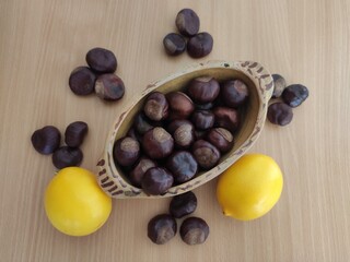 Yellow lemons and shiny brown chestnuts on the table