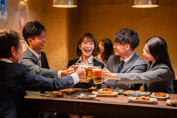居酒屋で盛大に乾杯をするビジネスパーソン