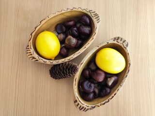 Yellow lemons and shiny brown chestnuts on the table