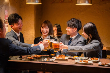 居酒屋で盛大に乾杯をするビジネスパーソン