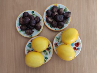 Yellow lemons and shiny brown chestnuts on the table