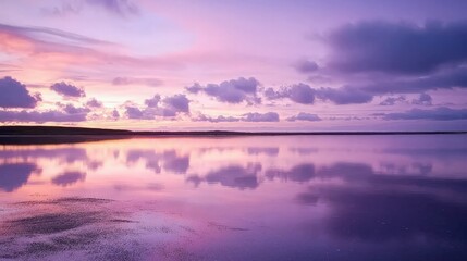 Fototapeta premium Serene sunset reflecting in calm waters, purple and pink hues, clouds.