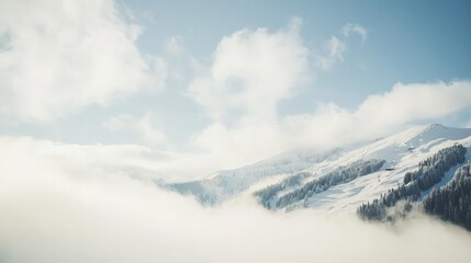 Snowy mountain peaks shrouded in mist under a bright sky.