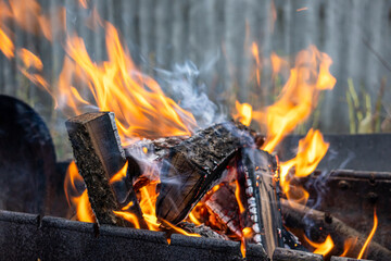 Burning wood. Flame fire sparks on dark abstract background. Cooking barbecue outdoor. Hellish fire...
