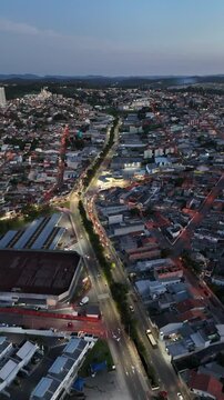 V&iacute;deo vertical a&eacute;reo de Mogi das Cruzes, S&atilde;o Paulo, &agrave; noite, mostrando a cidade iluminada com suas ruas movimentadas e a paisagem urbana, destacando a energia vibrante da cidade paulista