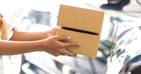 Human hand holding a parcel box,Woman holding cardboard parcel box at front door of house. Female hand holding brown eco-friendly parcel box. Delivery man.