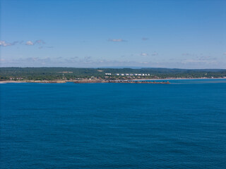 Coastal view of serene shoreline under clear blue sky in tranquil setting